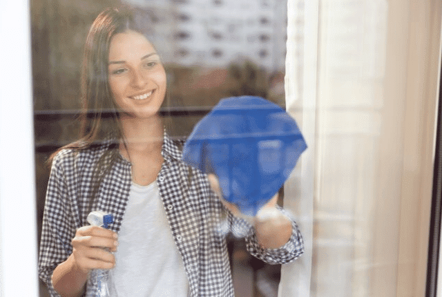 ניקוי עצמאי לחלונות, אישה מבריקה חלון עם מטלית